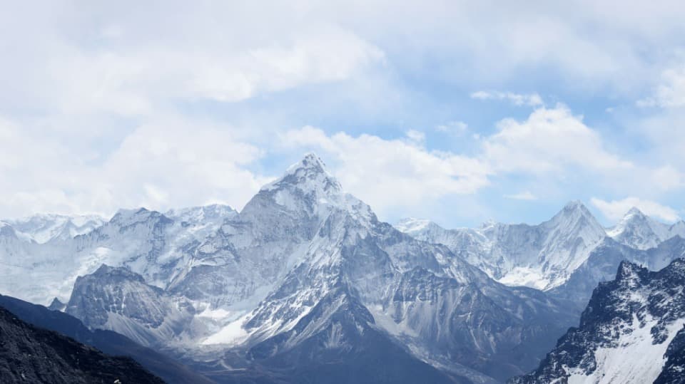 Snow-capped mountain range rising above the clouds